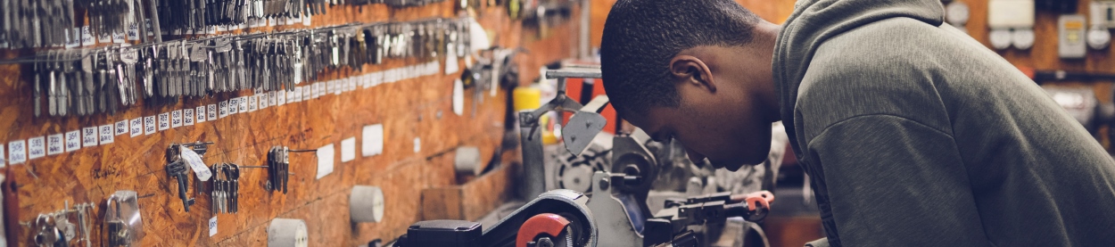 Photo of a man at a workbench making keys